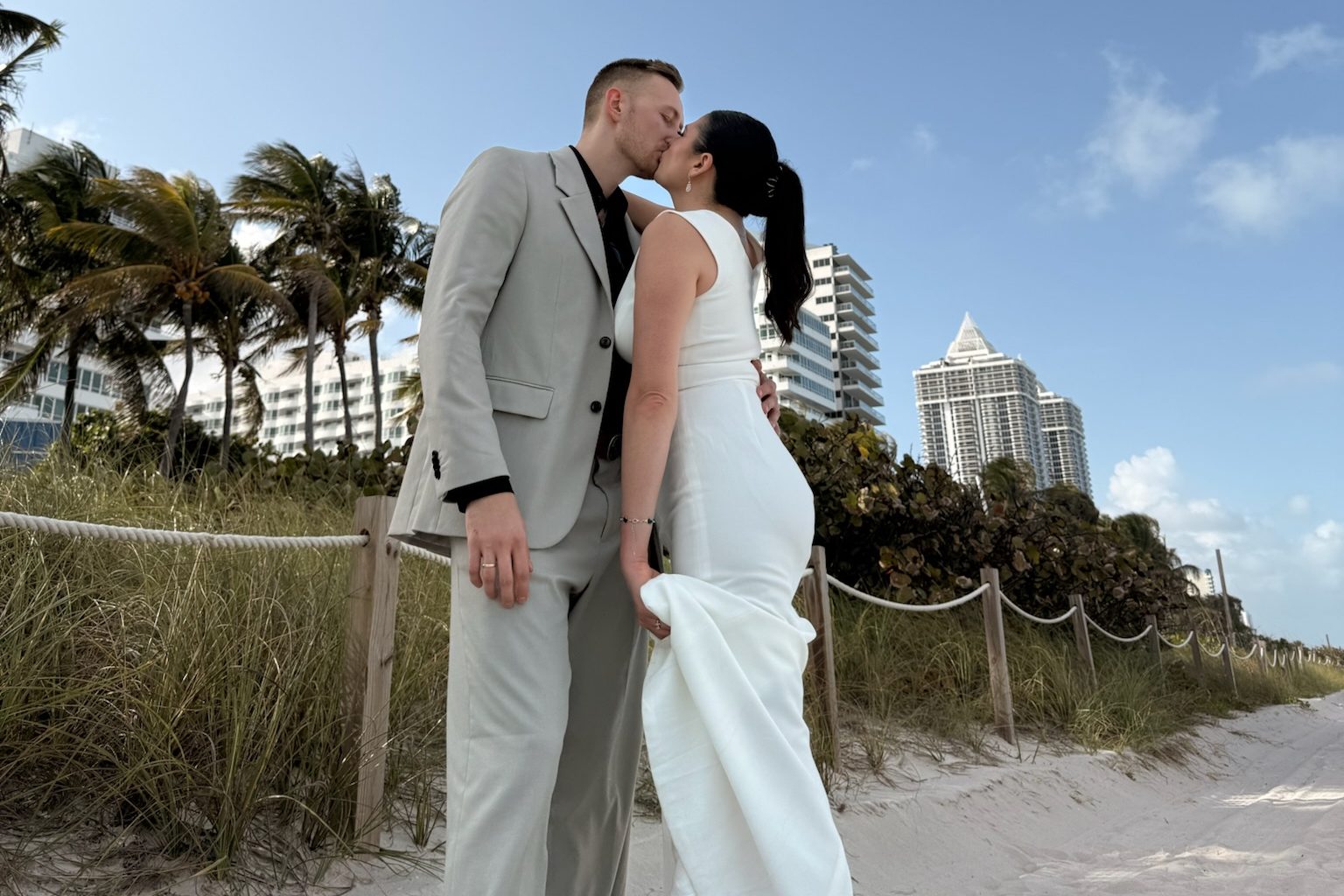 Couple kissing on a South Florida beach under a blue sky