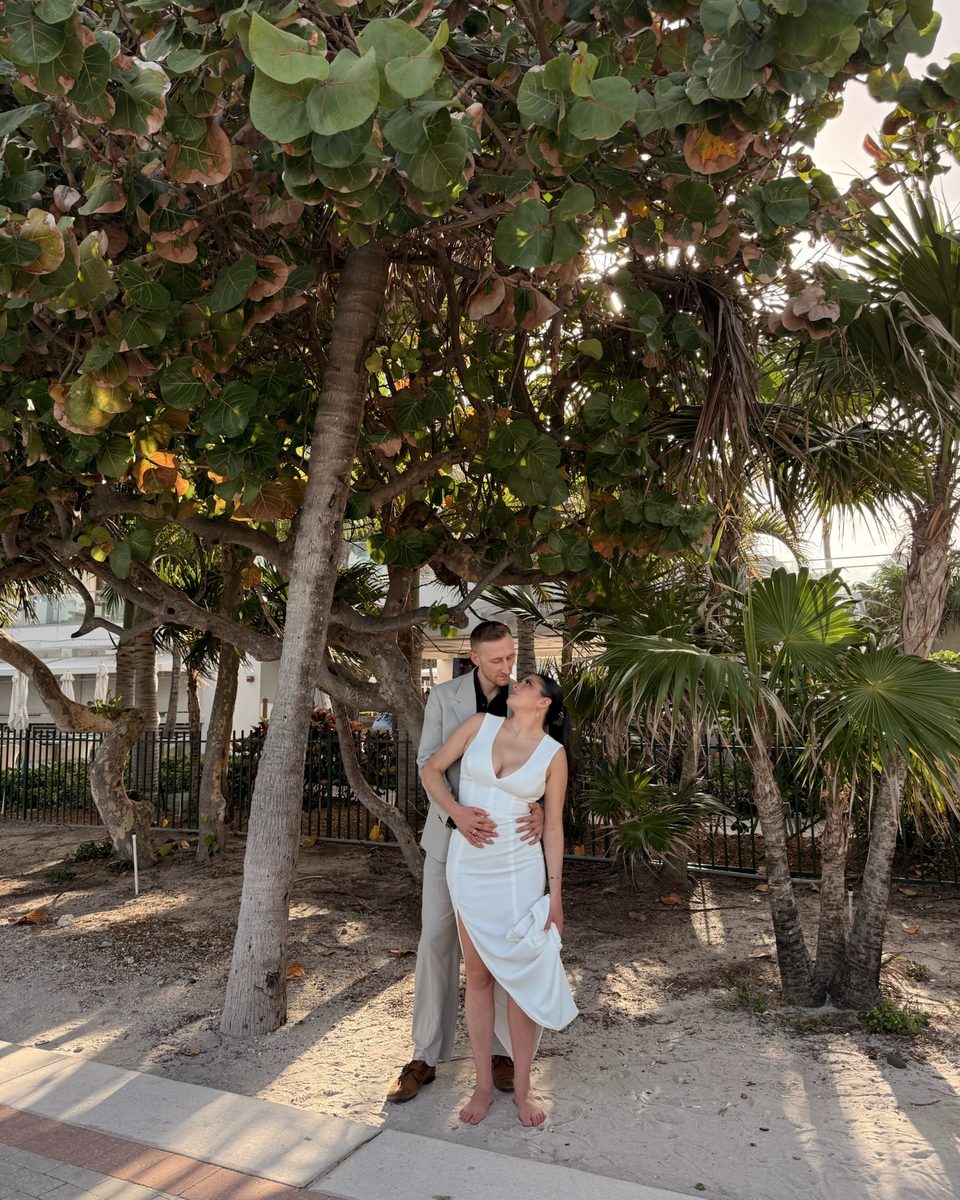 Couple standing together in a grove of sea grape trees