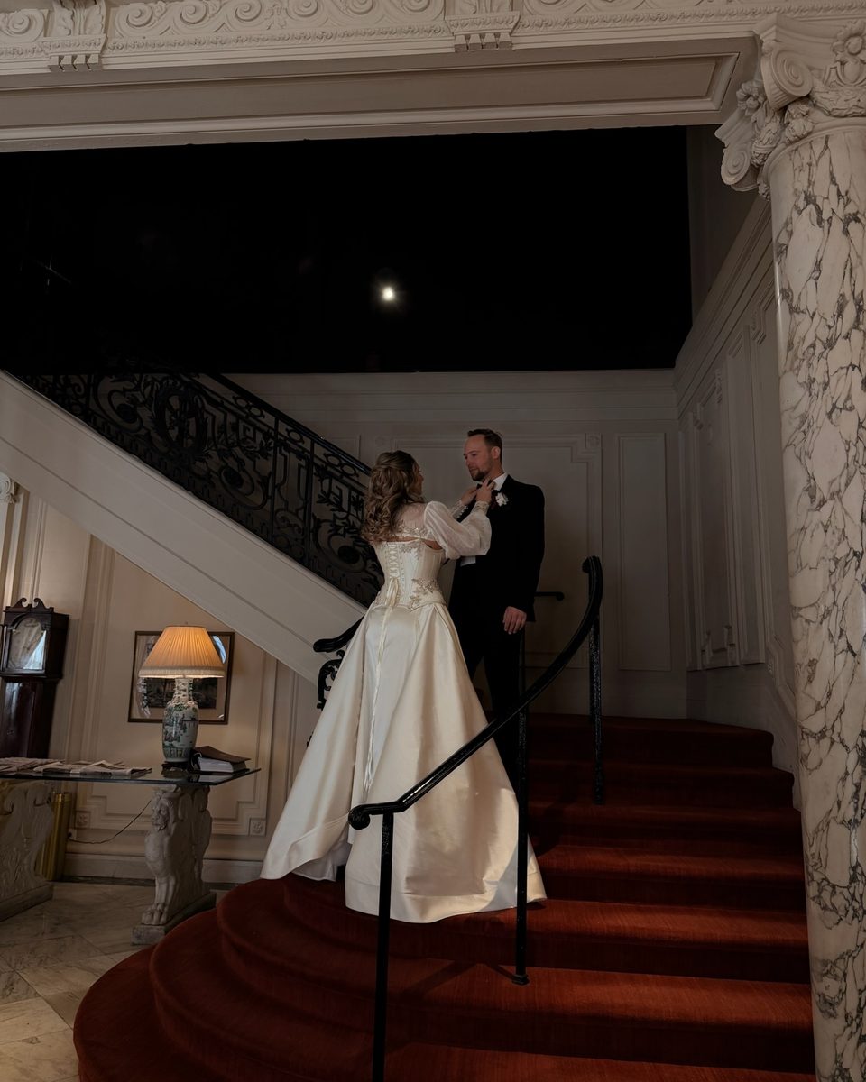 Couple on a red-carpeted staircase in the evening